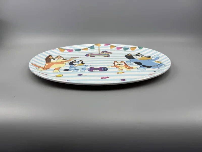 P210 melamine plate sample with a colourful cartoon print, photographed on a grey worktop