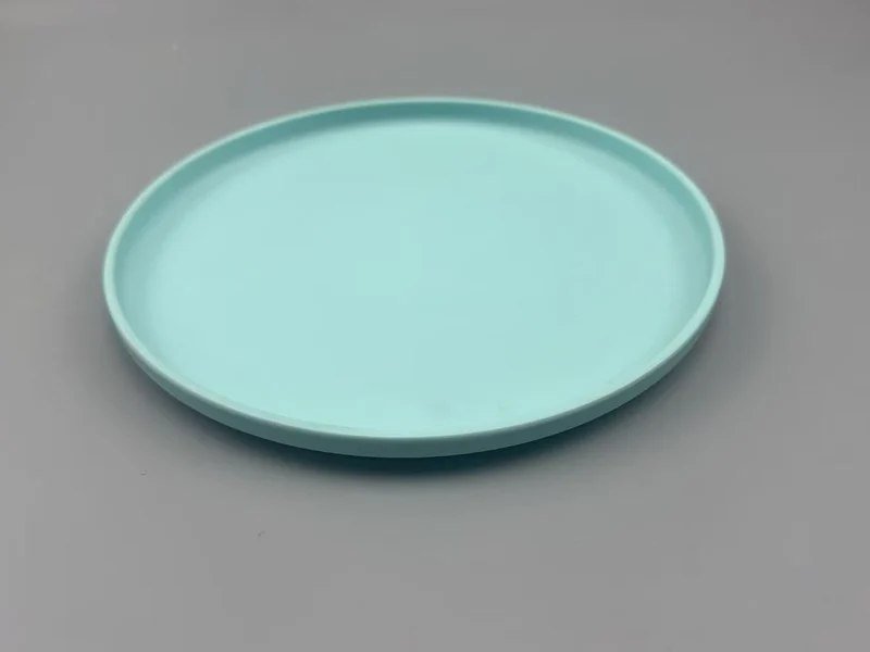 Plain light turquoise P222 melamine plate sample on a grey worktop